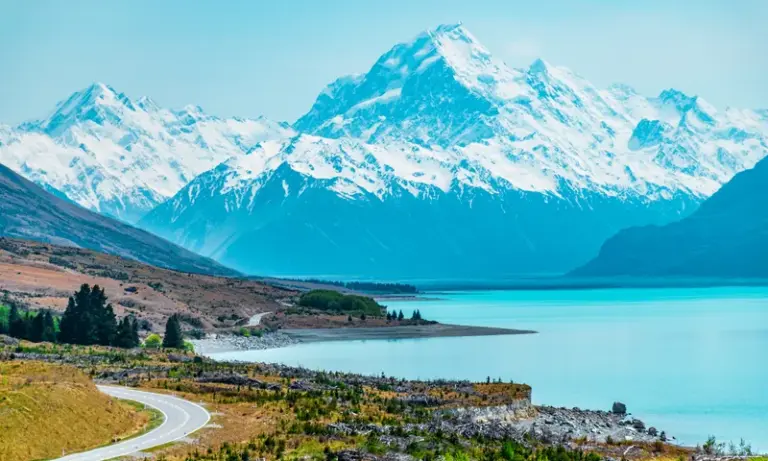 Snow-capped mountains above a turquoise alpine lake